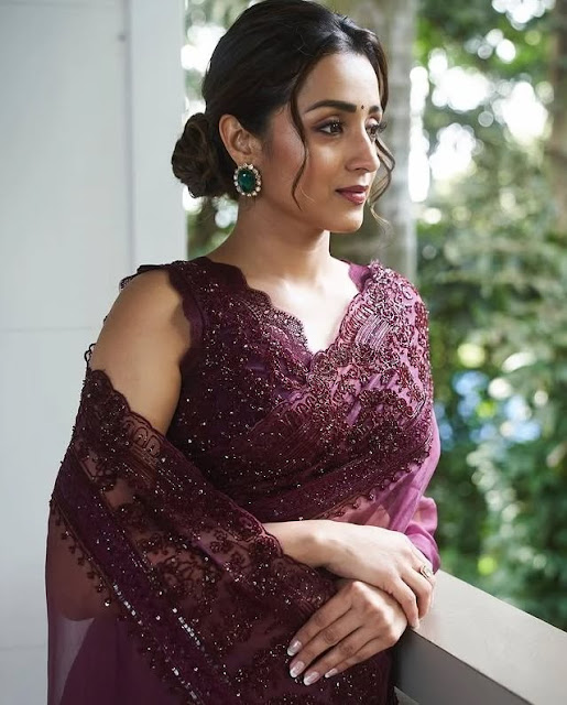 Trisha Krishnan smiling in elegant maroon saree