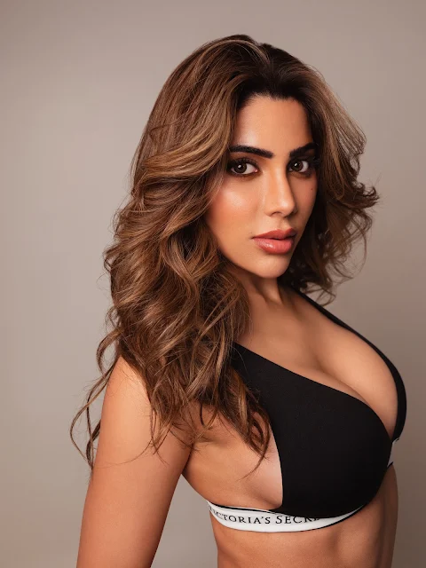 Nikki Tamboli in black top and distressed denim jeans
