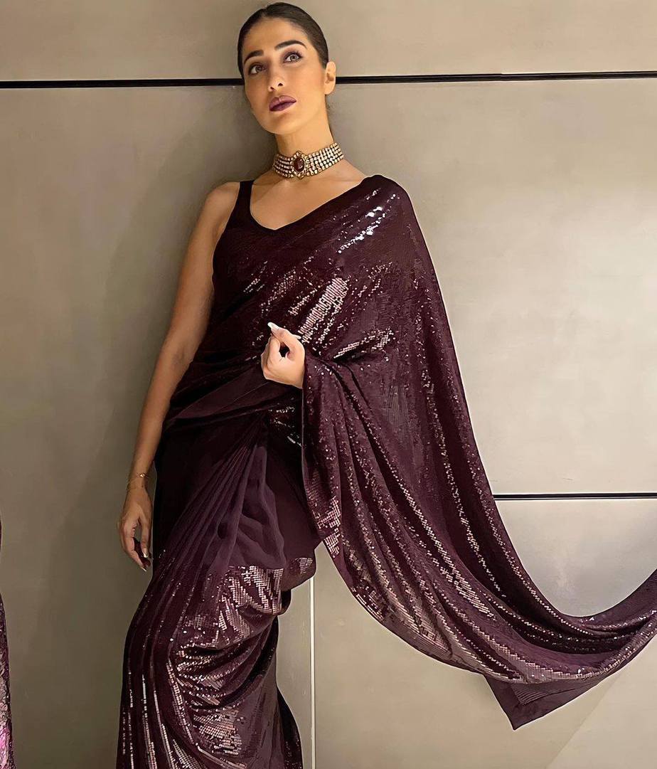 Raai Laxmi glitters in a wine sequinned saree at a wedding reception! How to style a saree for an evening party